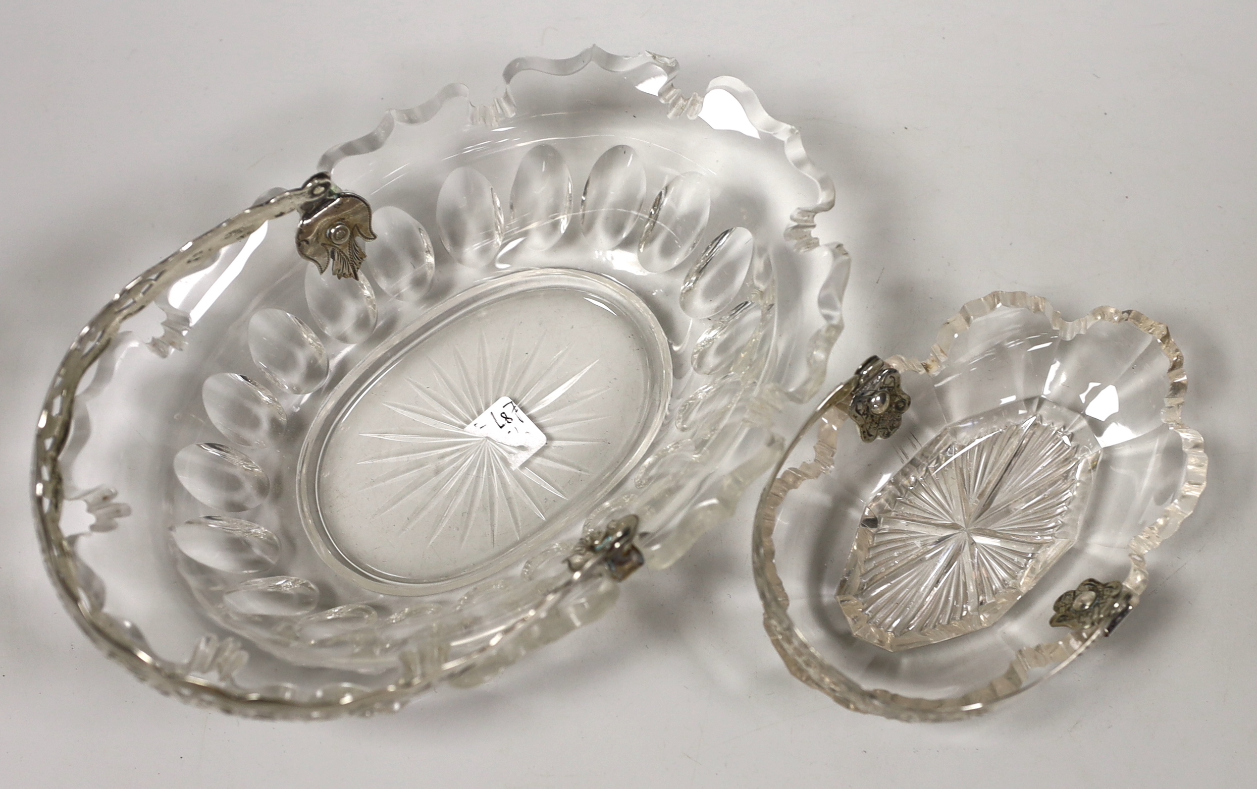 A late 19th century Dutch white metal mounted cut glass sweetmeat basket, length 21.4cm and a similar smaller basket.